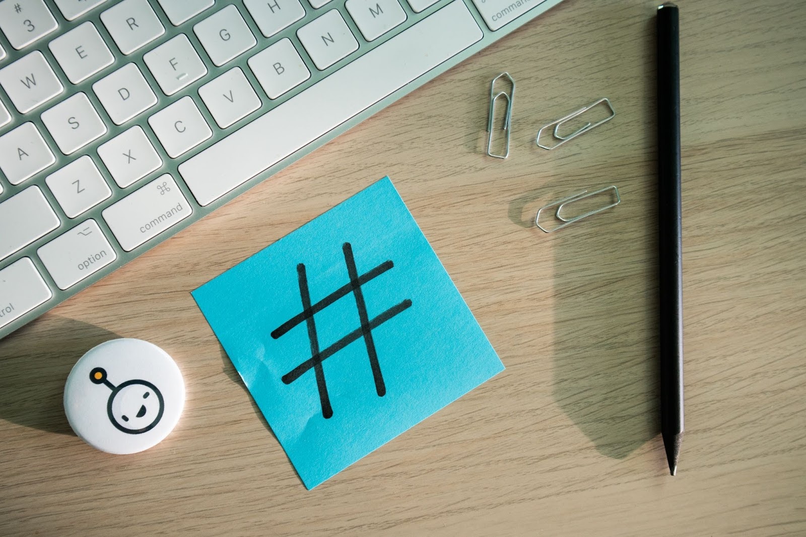hashtag on blue sticky note next to keyboard